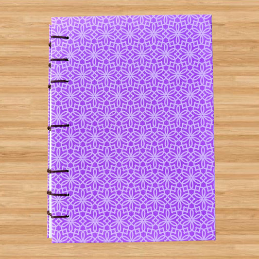 Purple Geometric Flower - A6 - Dot Grid - Coptic Bound - Fountain Pen Notebook - Handmade Journal with intricate purple geometric floral pattern and visible stitched binding on wooden surface