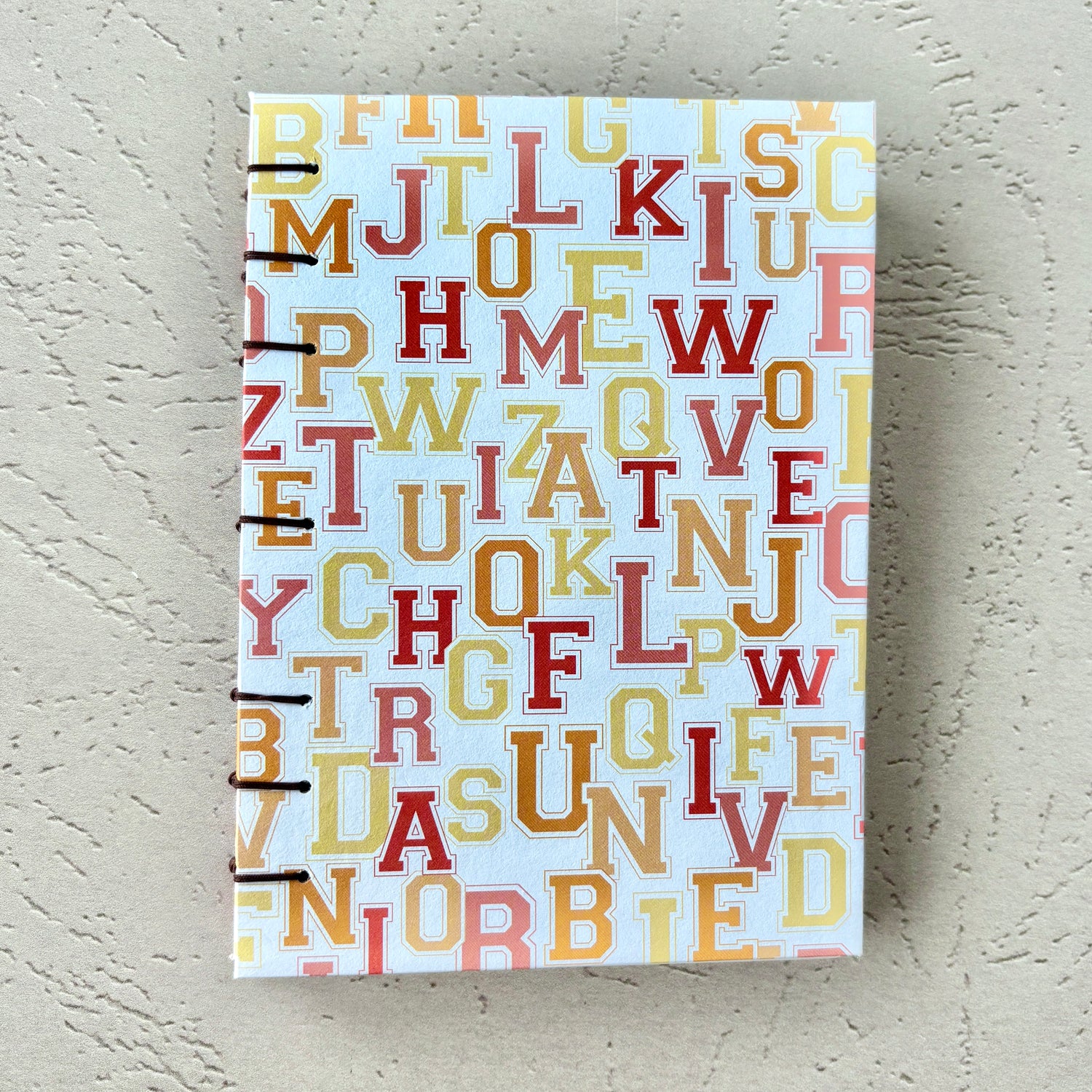 University Monogram - A6 - Lined - Coptic Bound - Fountain Pen Notebook - Handmade Journal with colorful alphabet monogram cover and visible coptic stitching