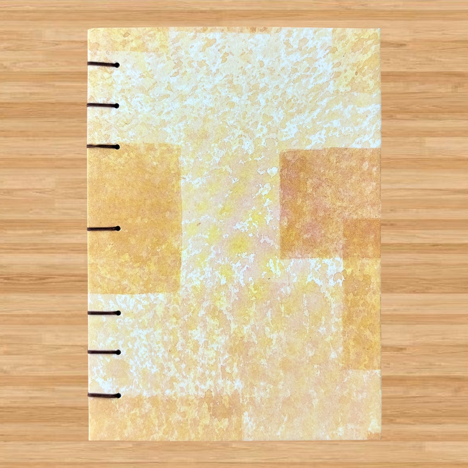 Blocked Orange - A6 - Lined - Coptic Bound - Fountain Pen Notebook - Handmade Journal with an abstract orange and cream cover and visible black coptic stitching