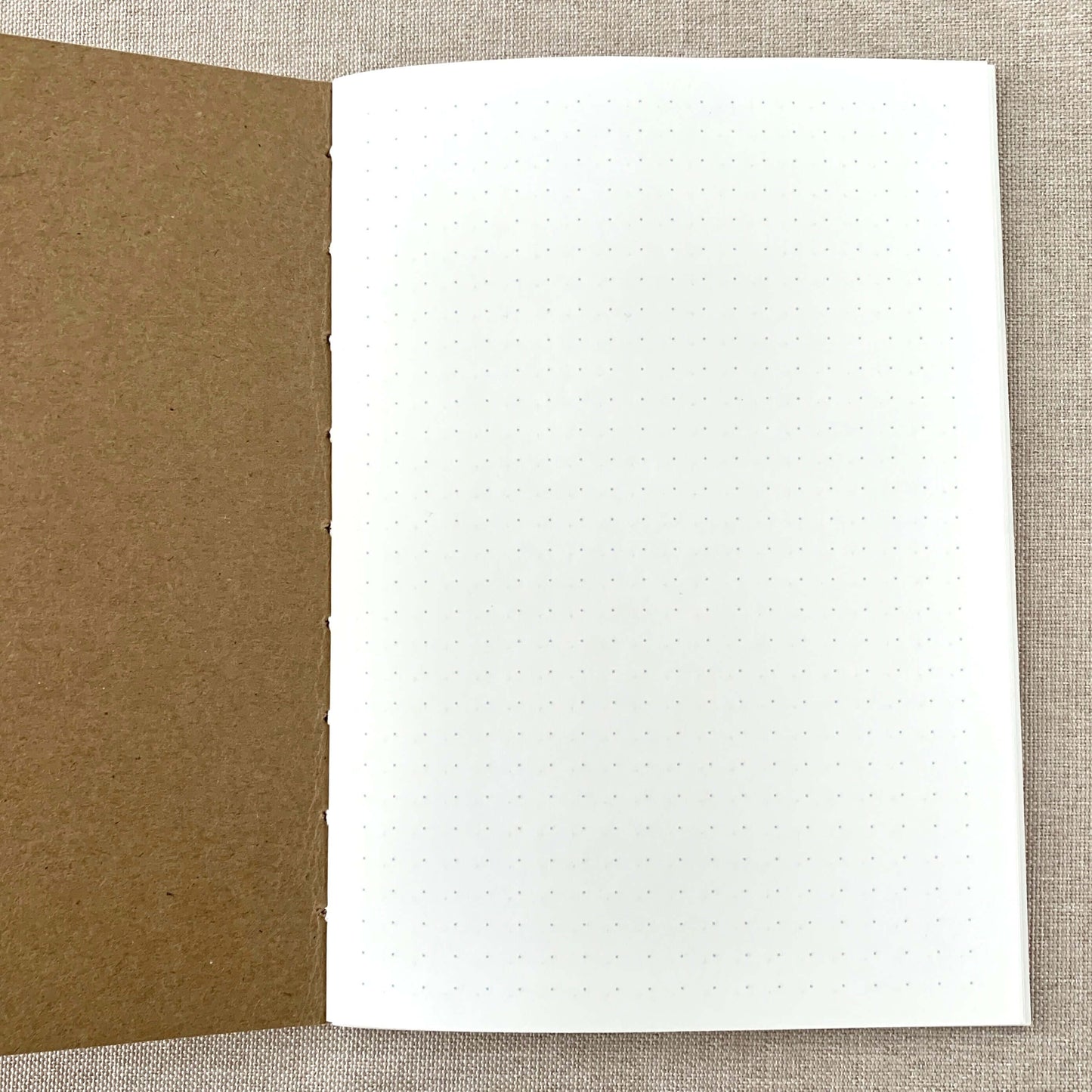 Open A6 Dot Grid Travelers Notebook Insert - Fountain Pen Friendly, Hand-Stitched Kraft Cover showing white dot grid paper and brown kraft cover, ideal for bullet journaling and fountain pen use.