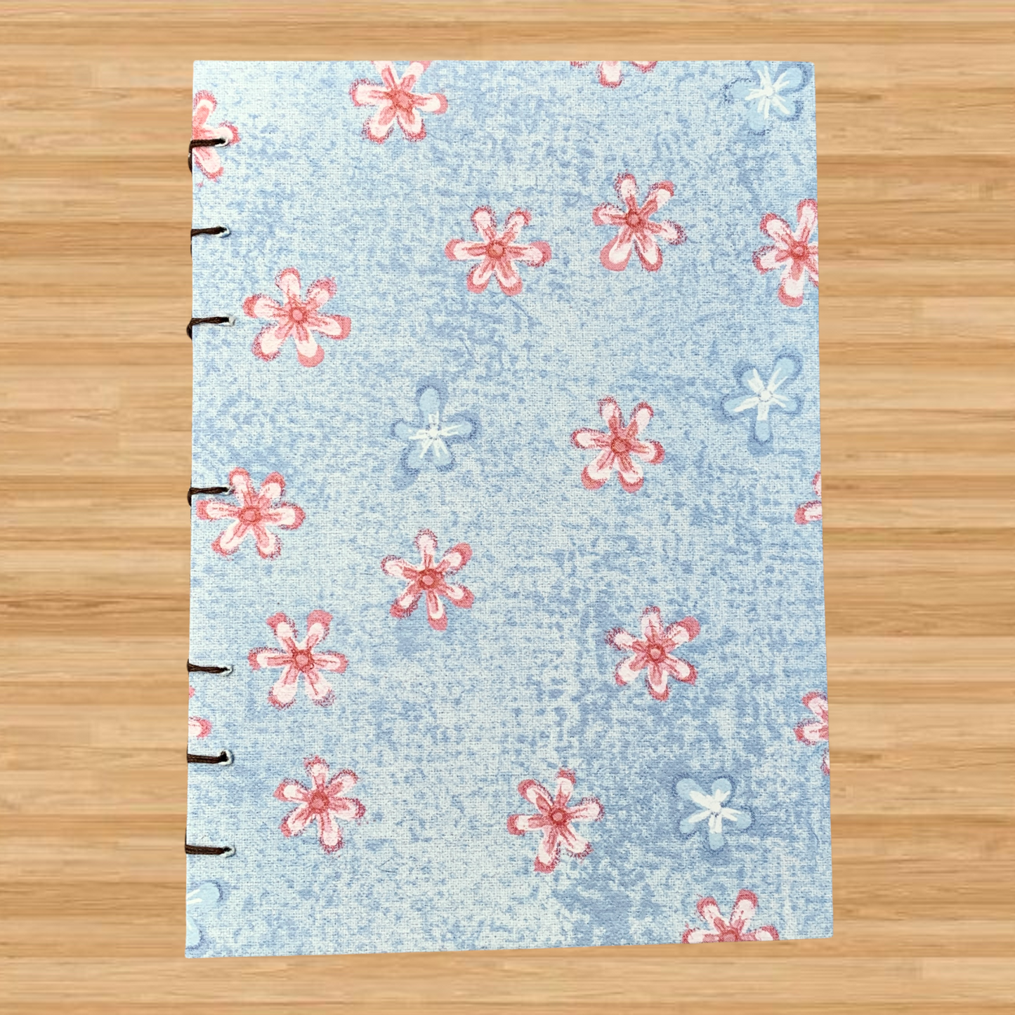 Handmade coptic-bound journal with light pink and light blue flowers on the cover, and dot grid paper inside that is fountain pen-friendly!